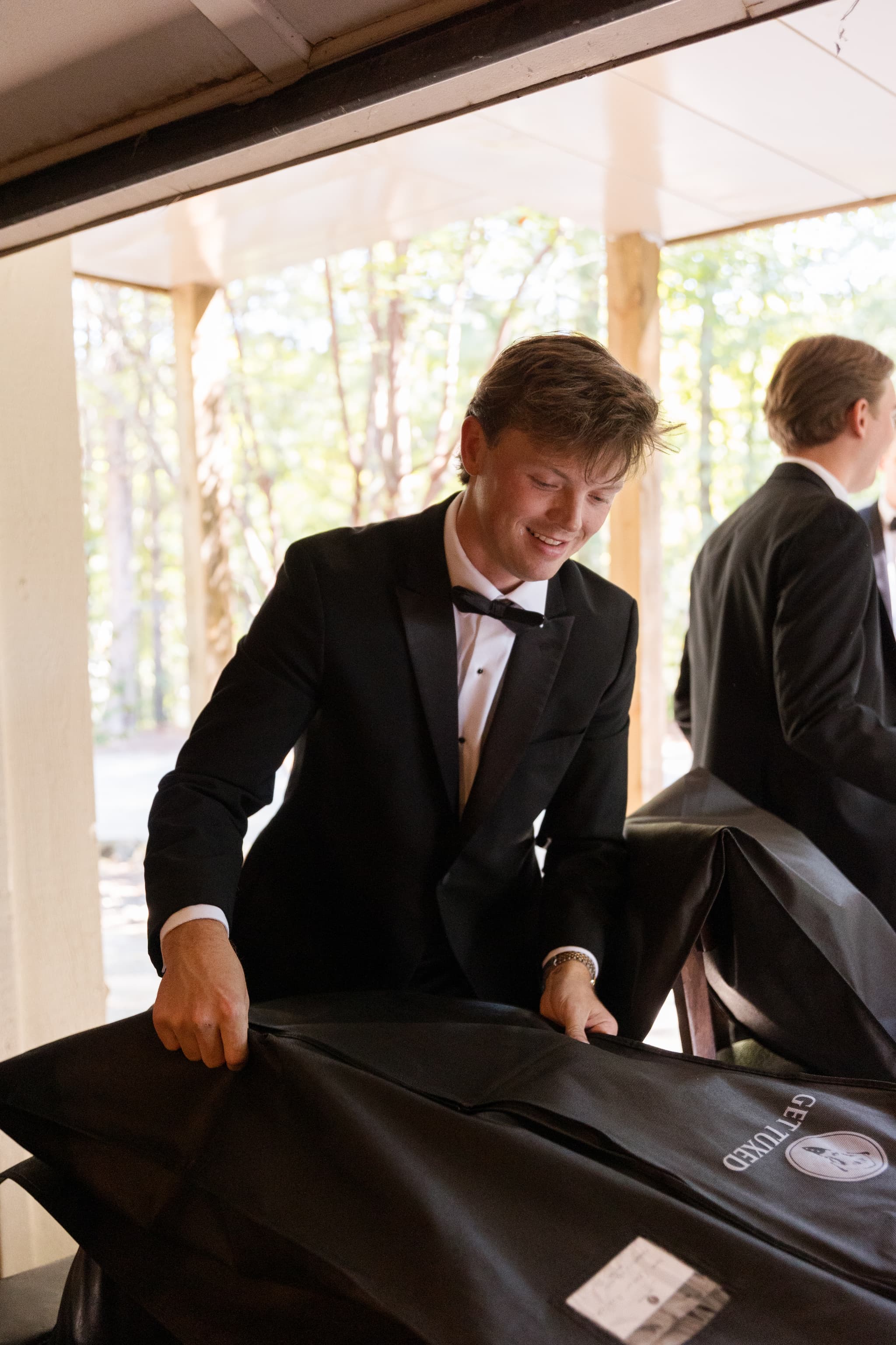Garrett unzipping a Get Tuxed garment bag